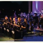 JEUNESSES MUSICALES WORLD BIG BAND Potrebbe essere un'immagine raffigurante 5 persone, tromba, clarinetto, oboe, violino, sassofono, flauto, microfono, violoncello, concerto e testo